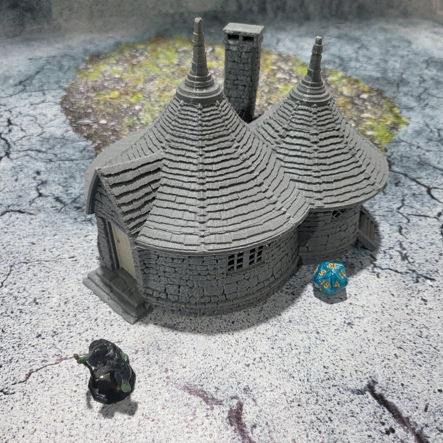 A highly detailed 3D-printed model of the Dragonspire Gamekeeper&#39;s Lodge, featuring two rooms, a fireplace with chimney, front and back doors, and a round roof design.