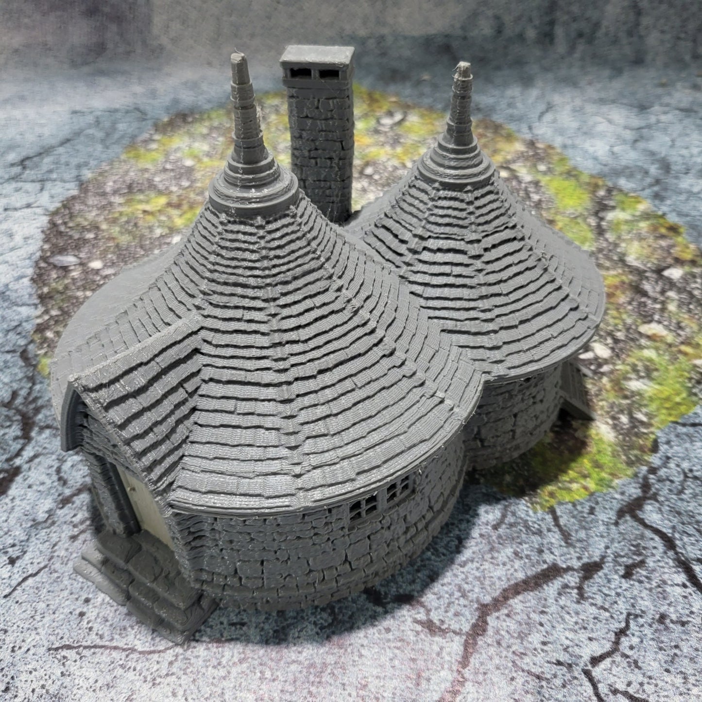 A highly detailed 3D-printed model of the Dragonspire Gamekeeper&#39;s Lodge, featuring two rooms, a fireplace with chimney, front and back doors, and a round roof design.