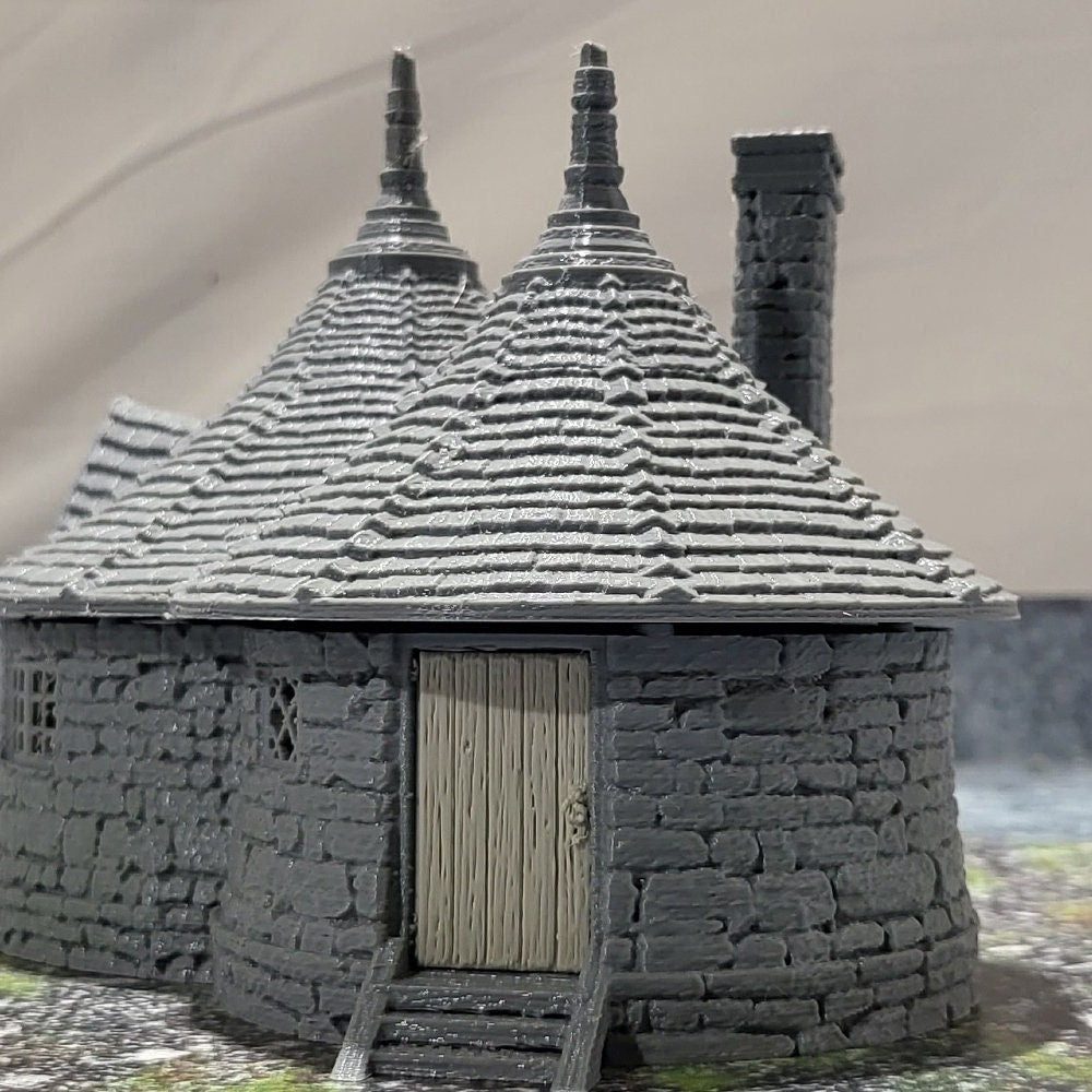 A highly detailed 3D-printed model of the Dragonspire Gamekeeper&#39;s Lodge, featuring two rooms, a fireplace with chimney, front and back doors, and a round roof design.