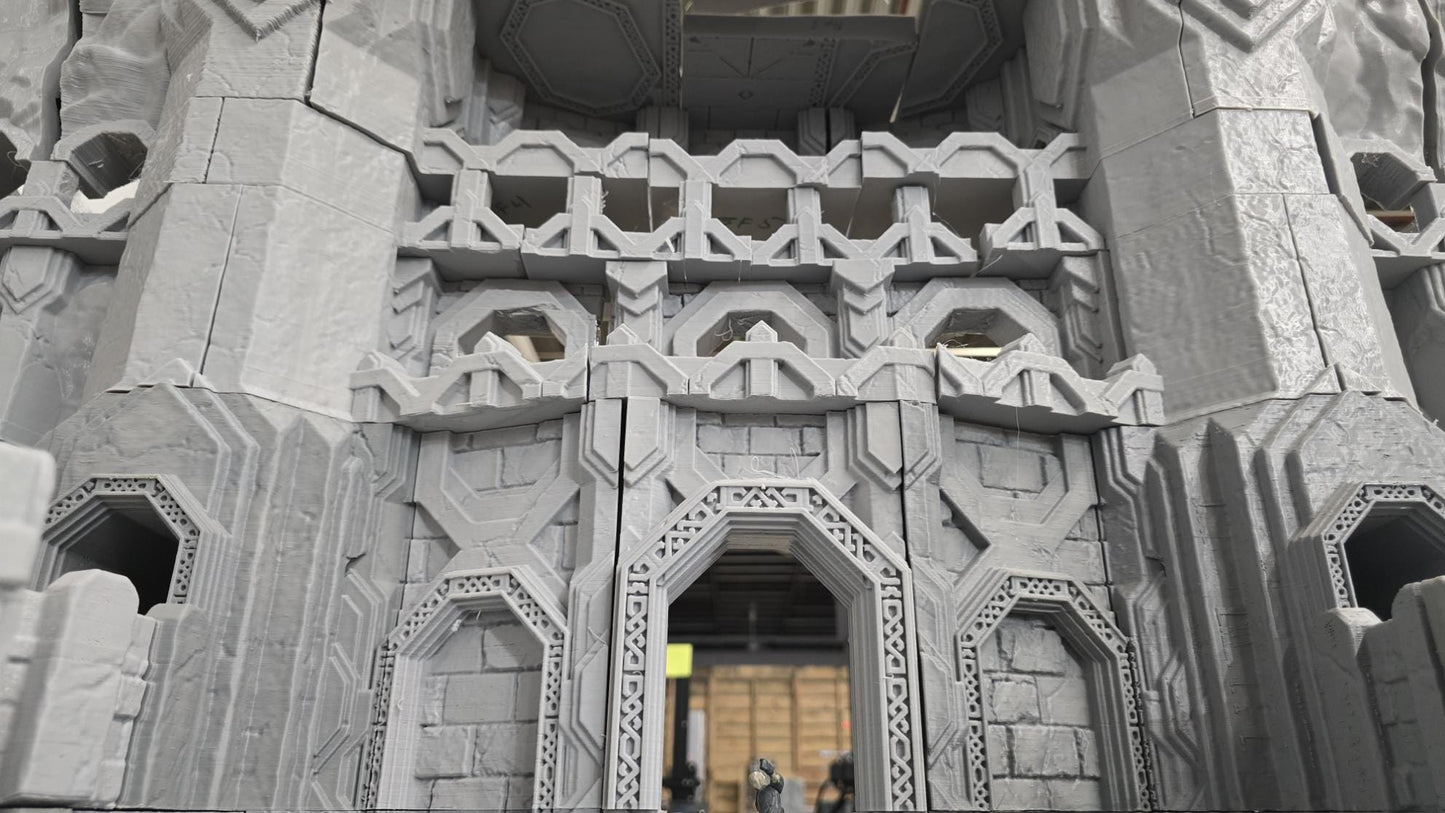 3D printed model of a Dwarf Mountain Stronghold, featuring towering stone structures, fortified walls, and intricate mountain carvings. The fortress includes multiple levels and archways, ideal for enhancing fantasy RPGs and wargaming scenarios.