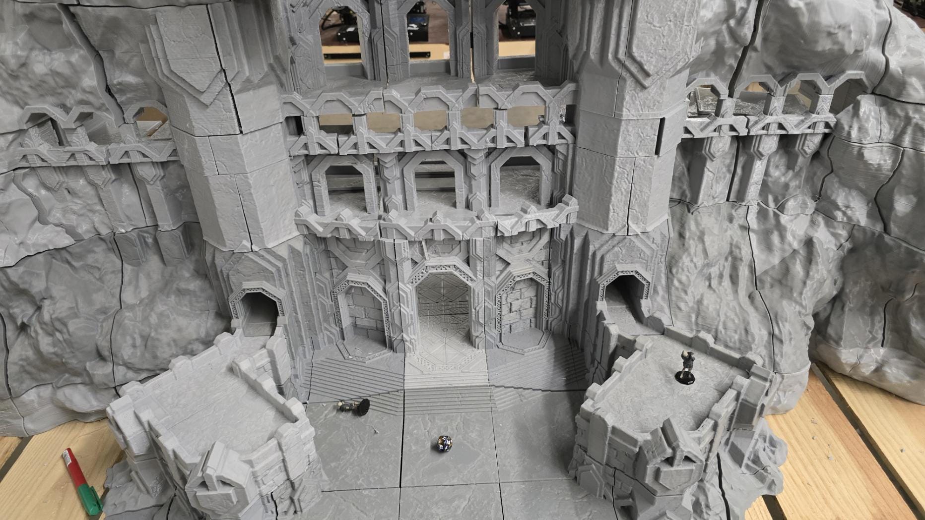 3D printed model of a Dwarf Mountain Stronghold, featuring towering stone structures, fortified walls, and intricate mountain carvings. The fortress includes multiple levels and archways, ideal for enhancing fantasy RPGs and wargaming scenarios.