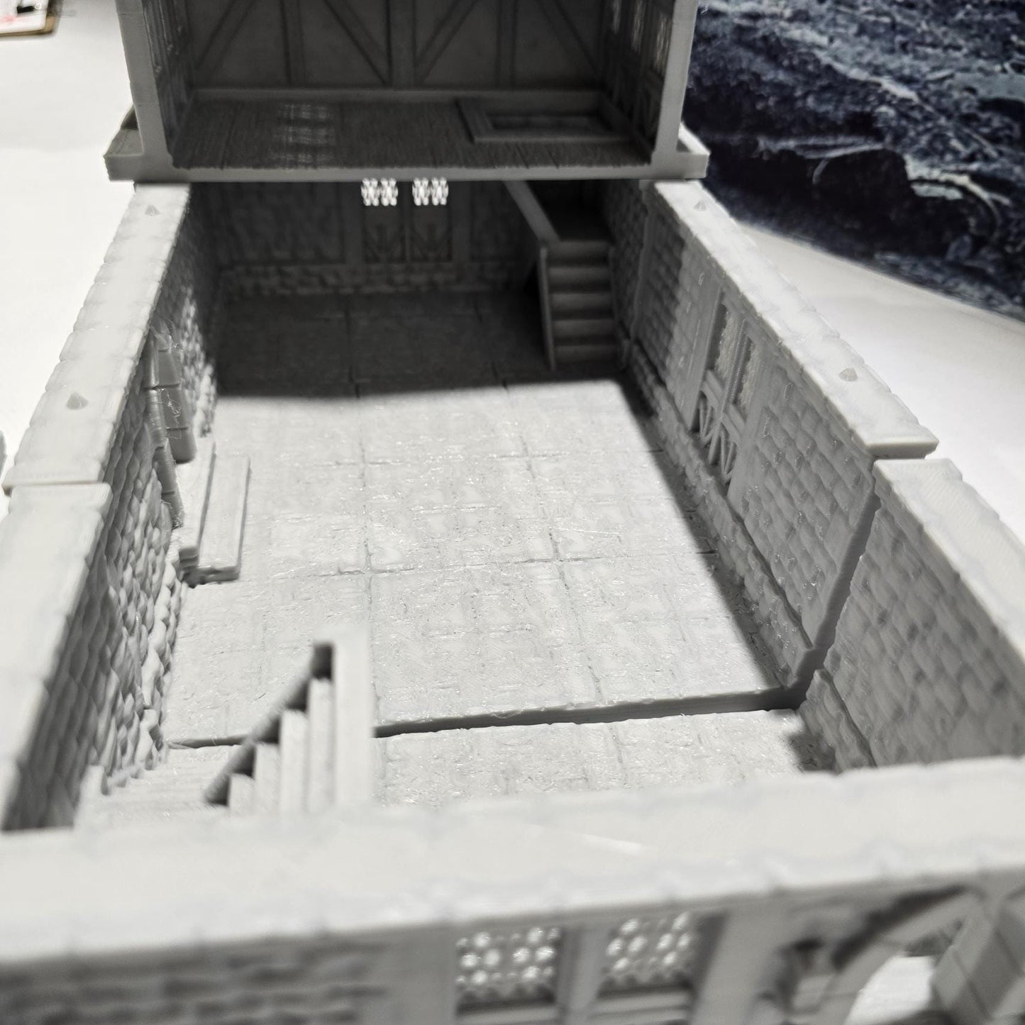 A detailed 3D-printed model of a modular warehouse for tabletop RPGs like DnD and Pathfinder. Features include brick walls, metal beams, storage crates, shelving units, and broken machinery. Perfect for urban and industrial gaming scenarios