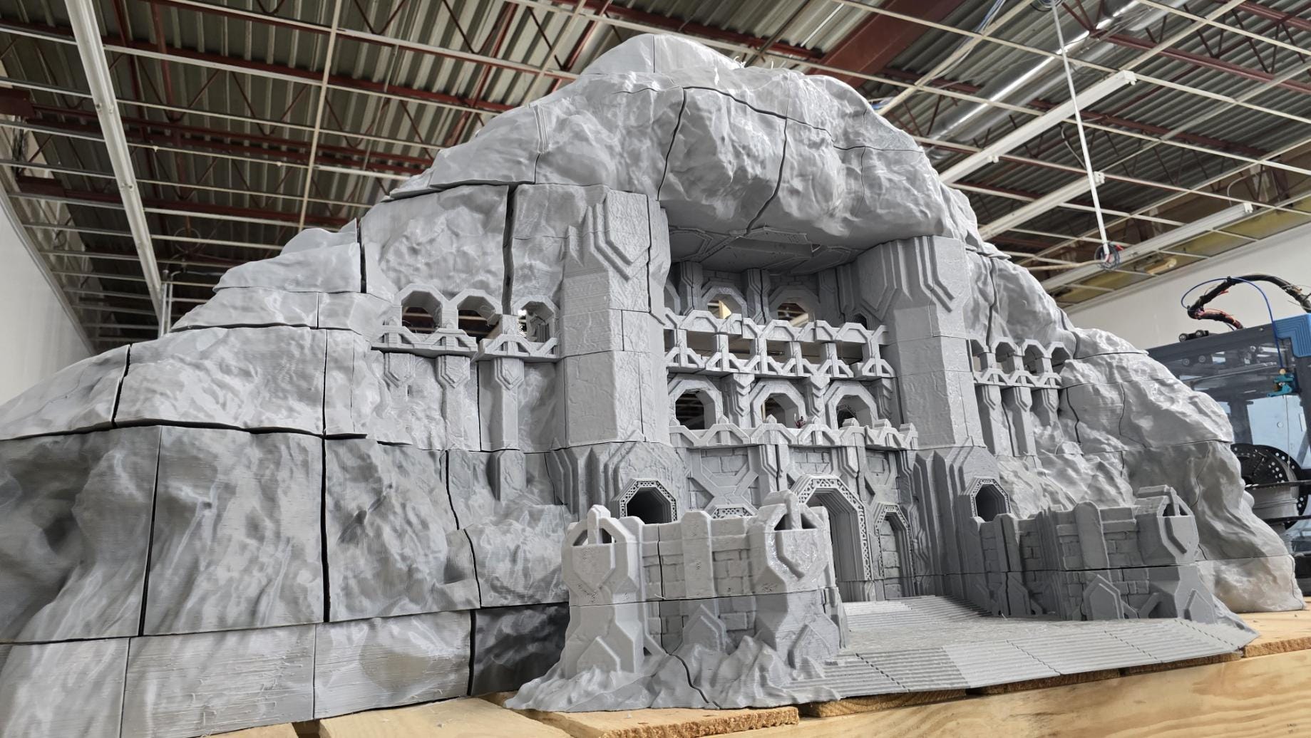 3D printed model of a Dwarf Mountain Stronghold, featuring towering stone structures, fortified walls, and intricate mountain carvings. The fortress includes multiple levels and archways, ideal for enhancing fantasy RPGs and wargaming scenarios.