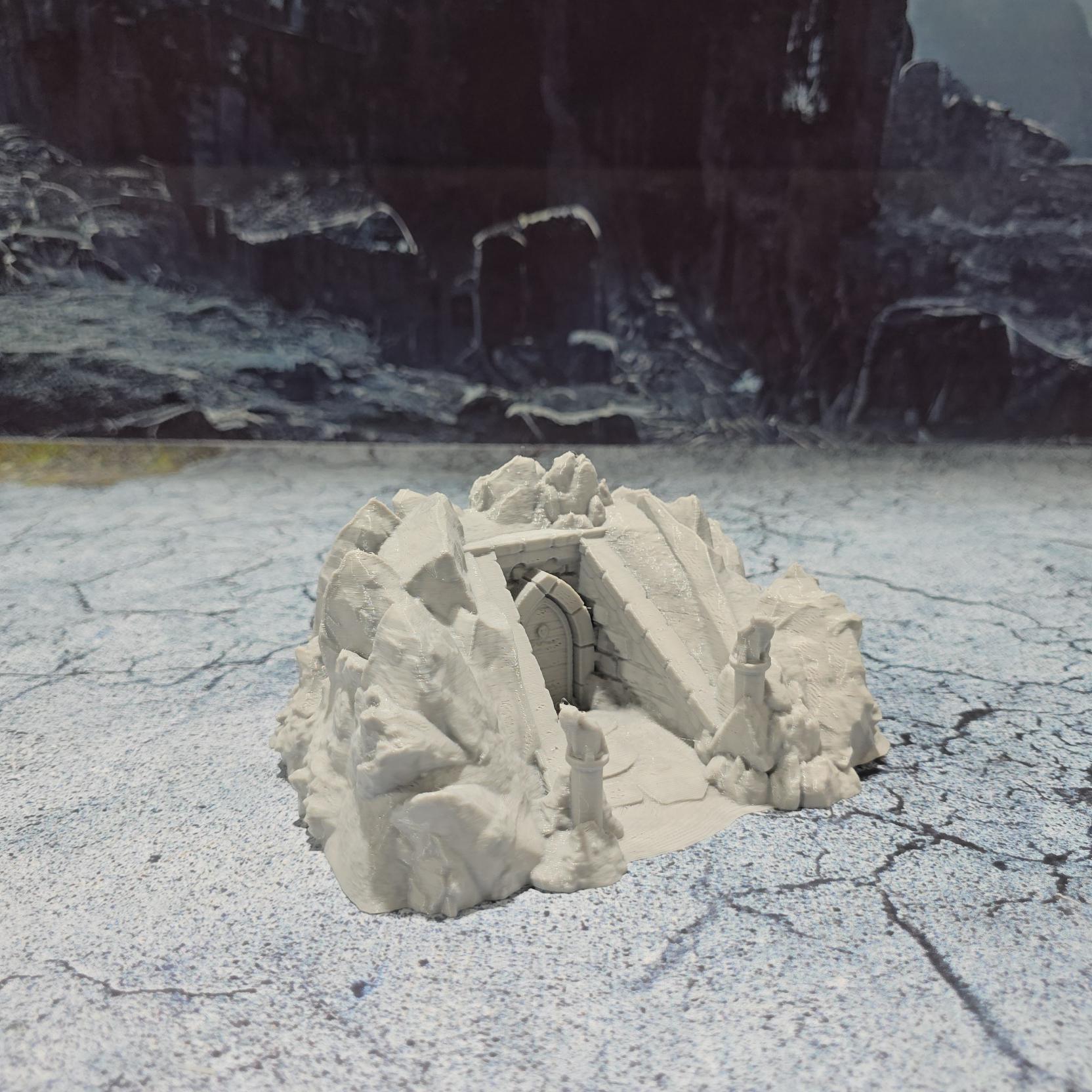 Discover the Drenn Cave Entrance, a detailed fantasy terrain piece featuring a weathered stone entrance guarded by ancient statues. Perfect for adding depth to your tabletop RPGs and wargames. Crafted from durable PLA