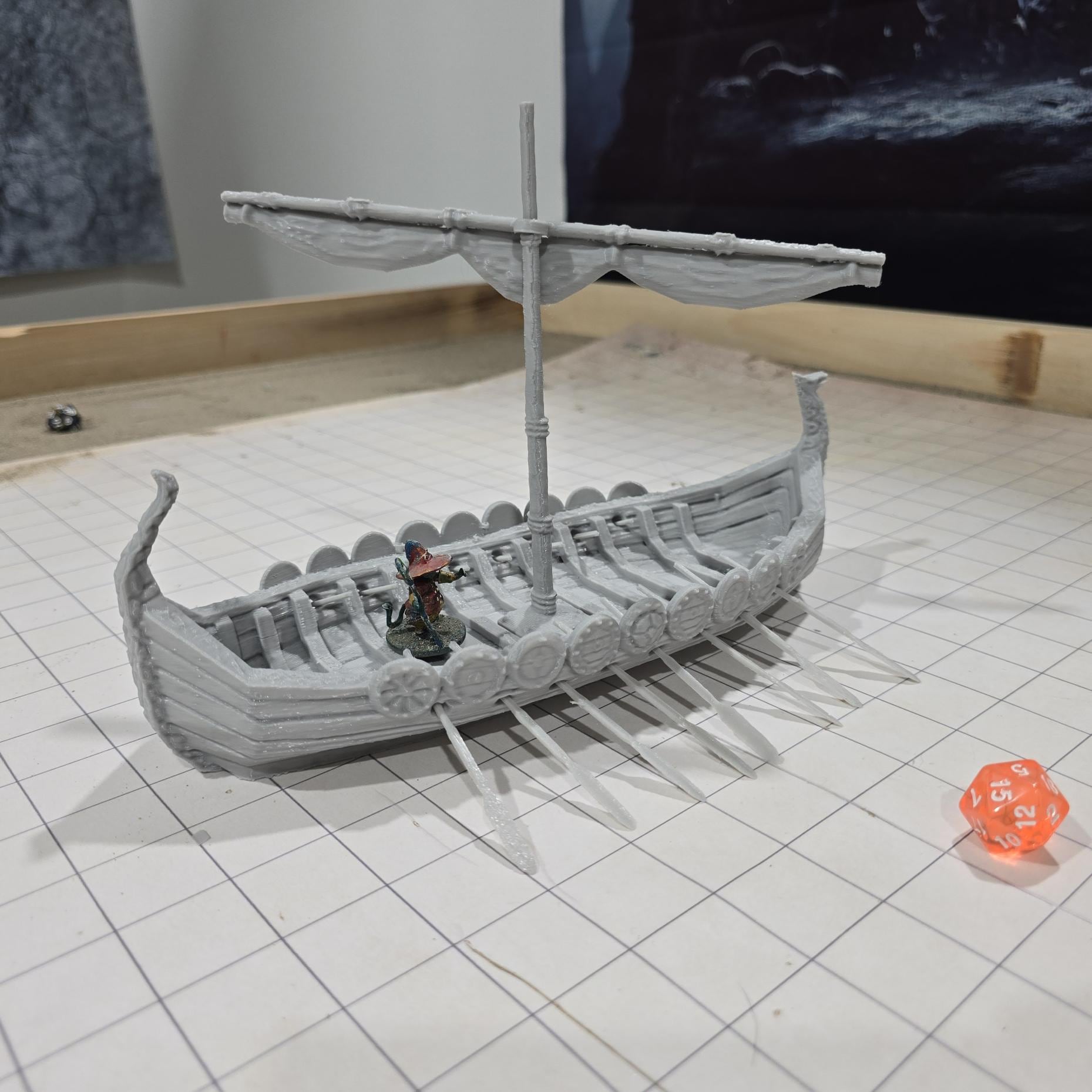 Detailed model of a Viking Long Ship with ornate carvings and shields, designed for use in tabletop RPGs and historical reenactments.